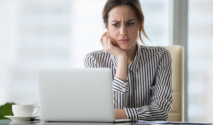 Junge Frau am PC, die sich ärgert