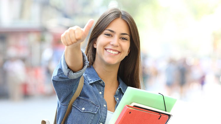 Junge Studentin lacht in die Kamera