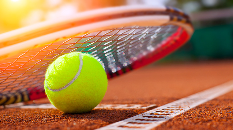 Rack und Tennisball auf einem Tennisplatz