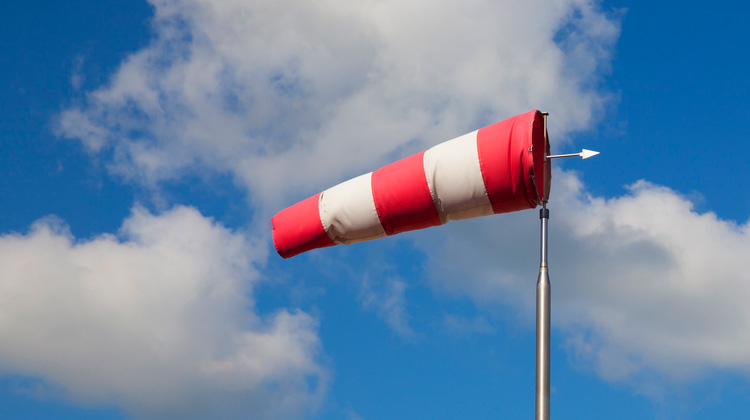 Ein aufgeblähter Windsack vor blauem Himmel und Wolken