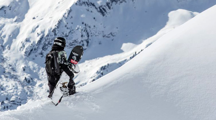 Freeride-Snowboarderin Géraldine Fasnacht auf einem verschneiten Grat in den Bergen