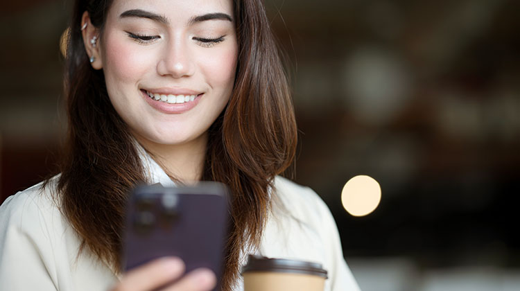 Junge Frau beim Mobile Banking auf dem Smartphone