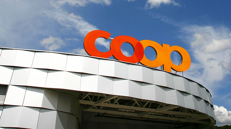 Coop-Logo auf Dach vor blauem Himmel