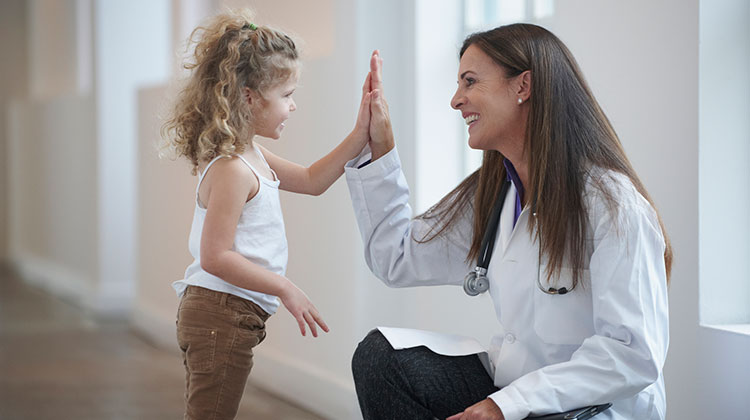 Junge Ärztin mit kleiner Patientin