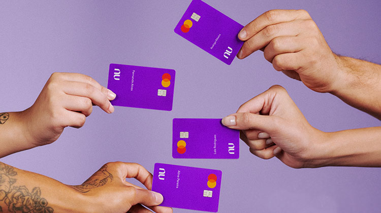 Vier Hände mit Debitkarten der Nubank