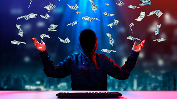 Hacker am PC wirft mit Dollarscheinen um sich