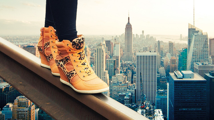 Eine Frau auf einem Stahlgeländer hoch über New York