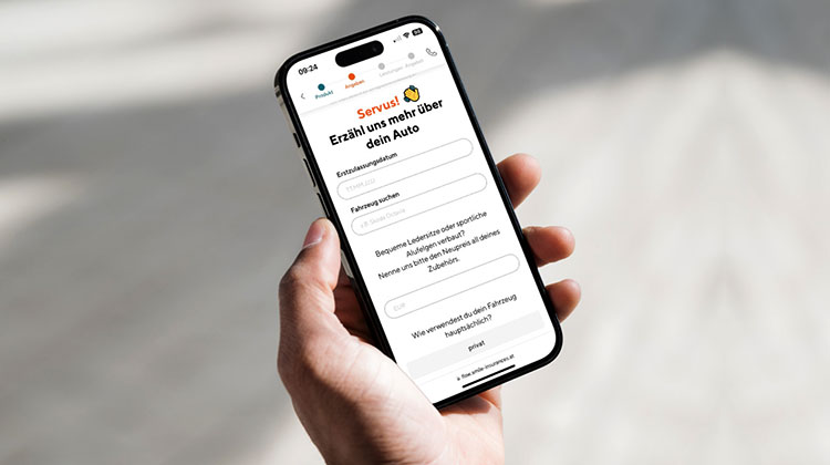 Hand mit Smartphone zeigt die Versicherungs-App Smile