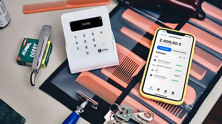 Ein kleines Zahlterminal von Sumup neben einem Smartphone, dass die erfassten Zahlungen anzeigt