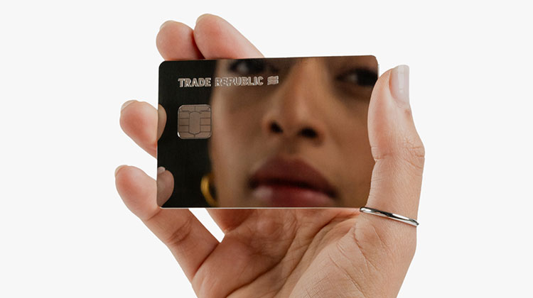 Eine Frauenhand hält die neue Mirror-Karte von Trade Republic