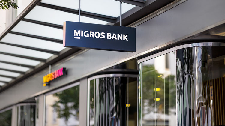 Eingang der Migros Bank mit Leuchtschrift