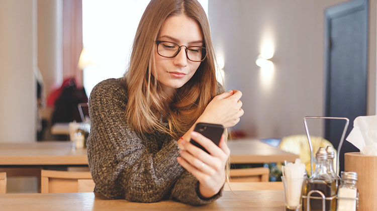 Junge Frau am Smartphone ist beschäftig mit ihrem Mobile Banking