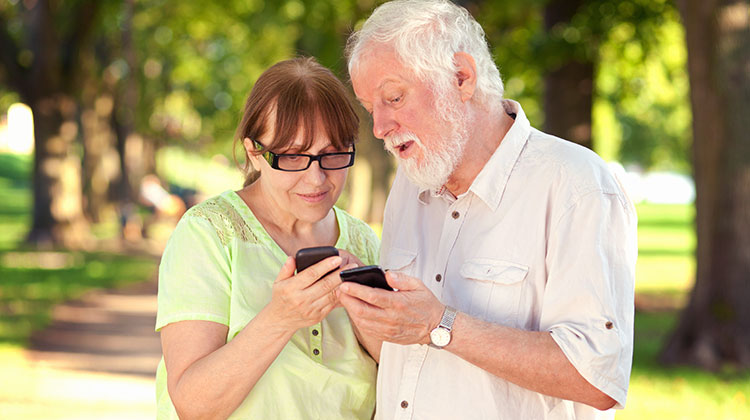 Seniorenpaar schaut auf seine Smartphones