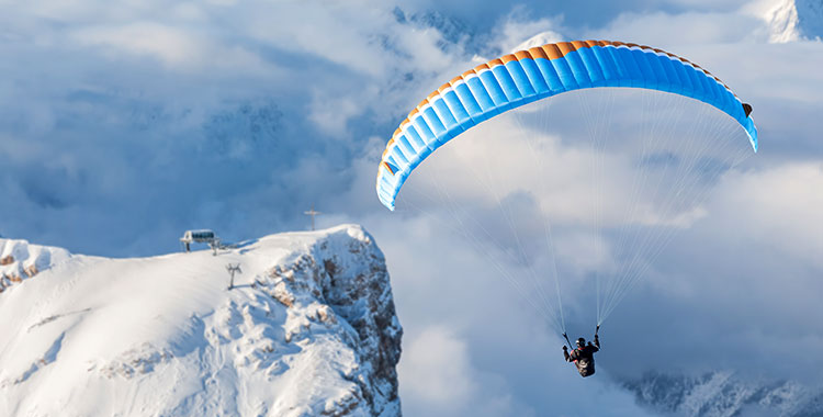 Gleitschirmpilot in den Alpen im Aufwind