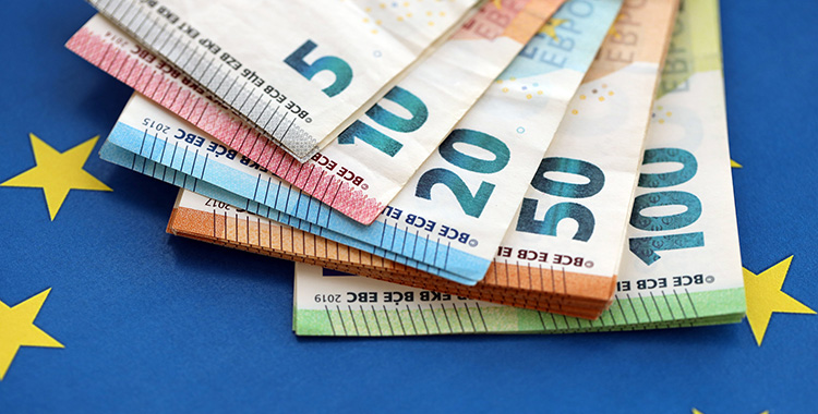 Euro-Banknoten als Fächer auf eine EU-Flagge