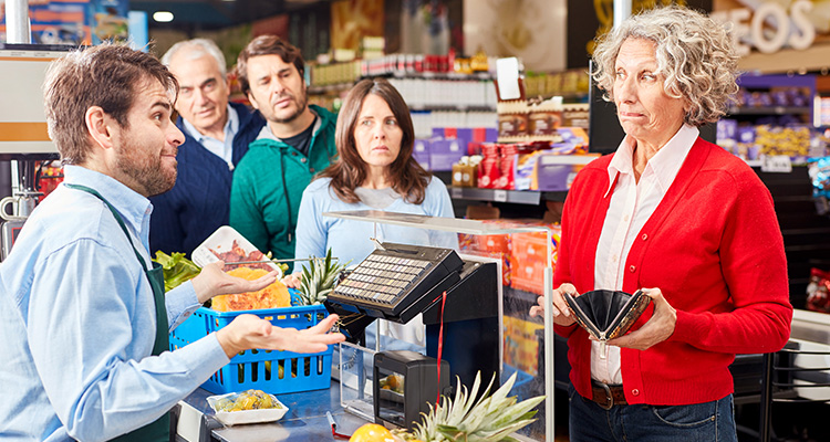Frau an der Supermarktkasse beim Bezahlen