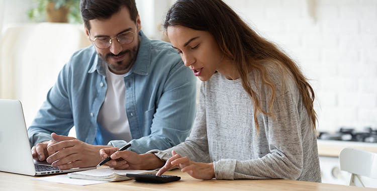 Junges Paar am Laptop prüft die Performance seiner Anlagen
