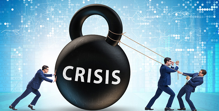 Manager in Anzügen zerren an einem Riesengewicht mit der Aufschrift Crisis