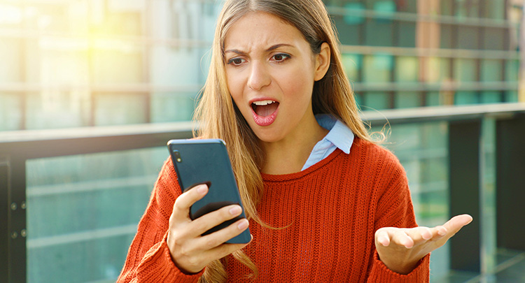 Verärgerte junge Frau am Smartphone