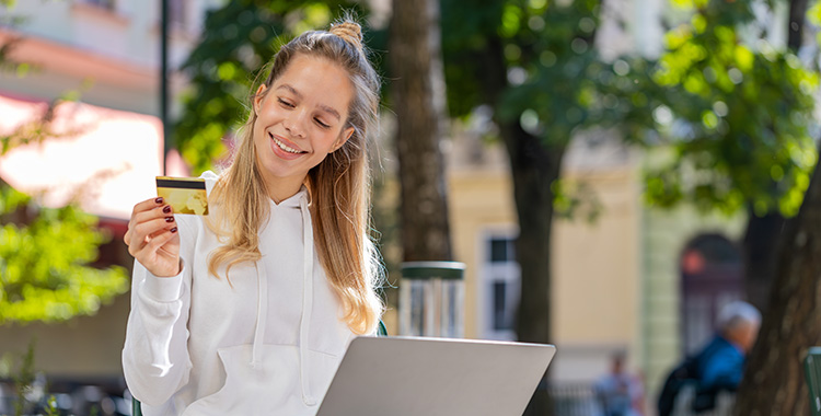 Junge Frau mit Kreditkarte und Laptop