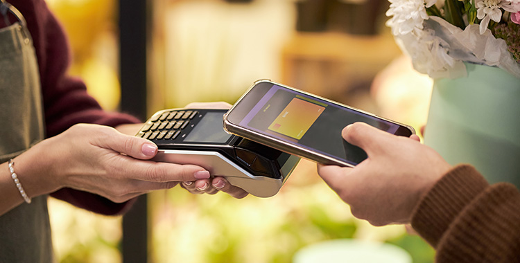 Mobiler Bezahlvorgang mit Terminal und Smartphone