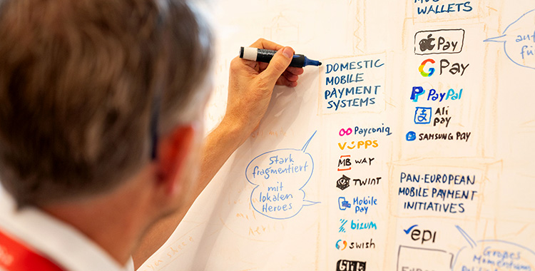 Mann schreibt und illustriert eine Tafel am Swiss Payment Forum