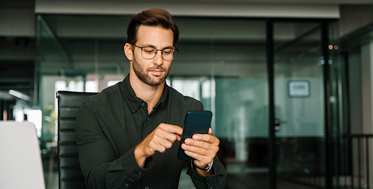 Junger Mann mit seinem Smartphone beschäftigt