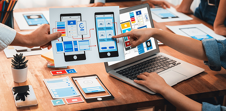 Hände, Charts und PCs auf einem Tisch als Symbol für Startups