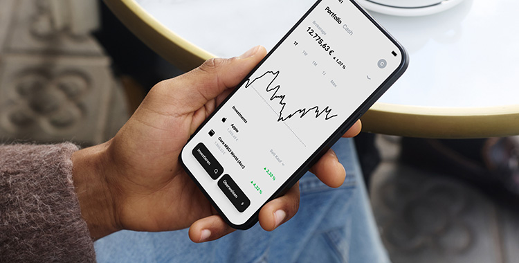 Eine Hand mit Smartphone zeigt die Benutzeroberfläche des Neo-Brokers Trade Republic