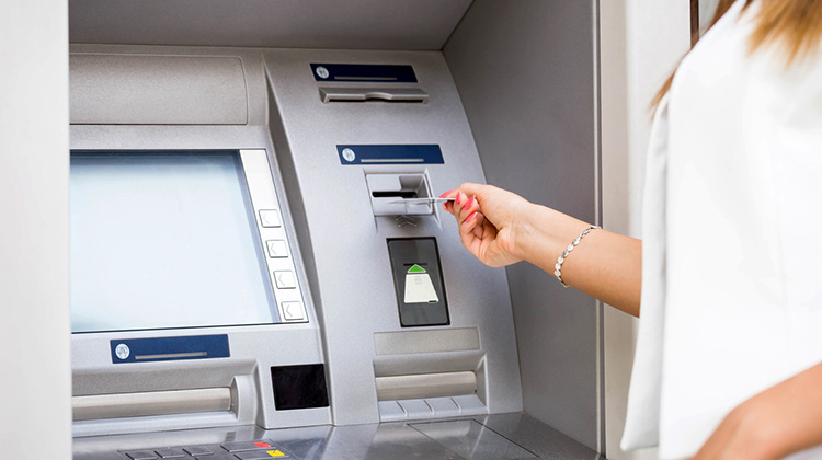 Geldautomat mit Frau beim Geldbezug