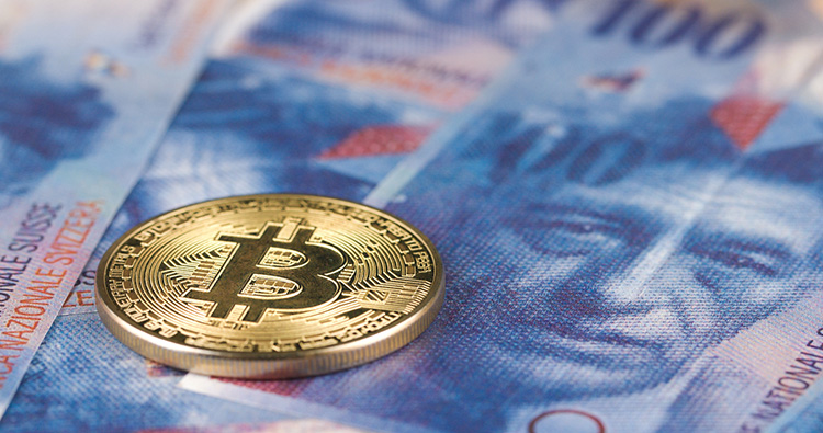 Bitcoin als Münze auf einer Schweizer Banknote