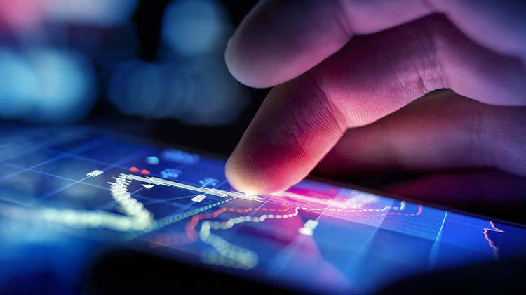Hand mit Smartphone, ein User checkt die Börsenkurse